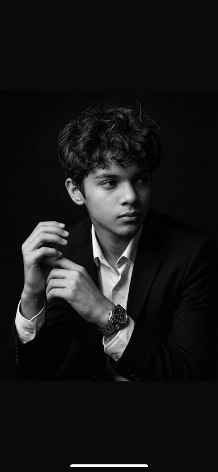Black-and-white portrait of Mujtaba Muneer wearing a suit